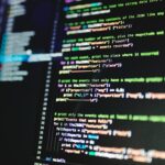 Close-up of colorful programming code displayed on a computer monitor with a dark background.
